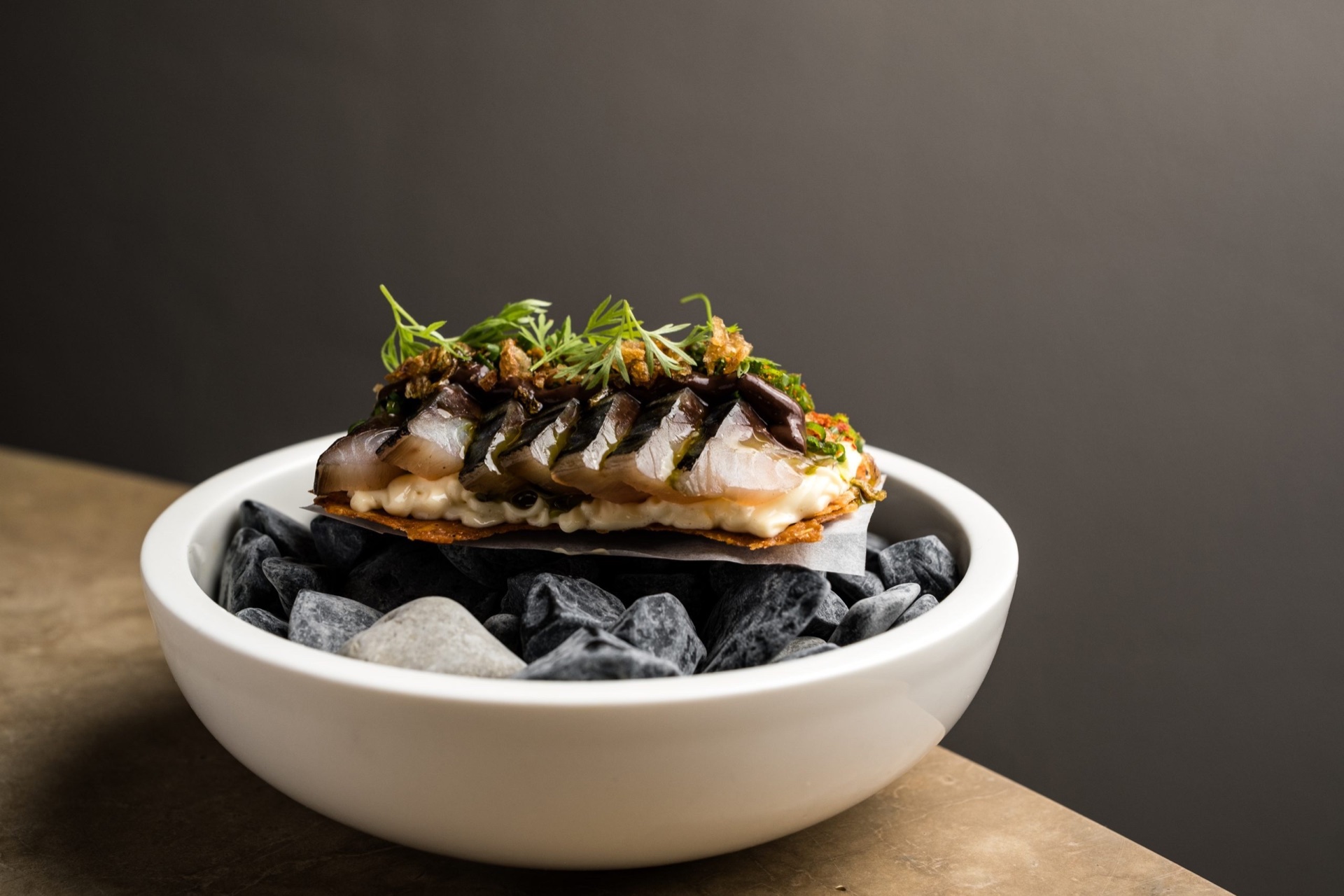 Gericht mit mariniertem Fisch und Kräutern in weißer Schale