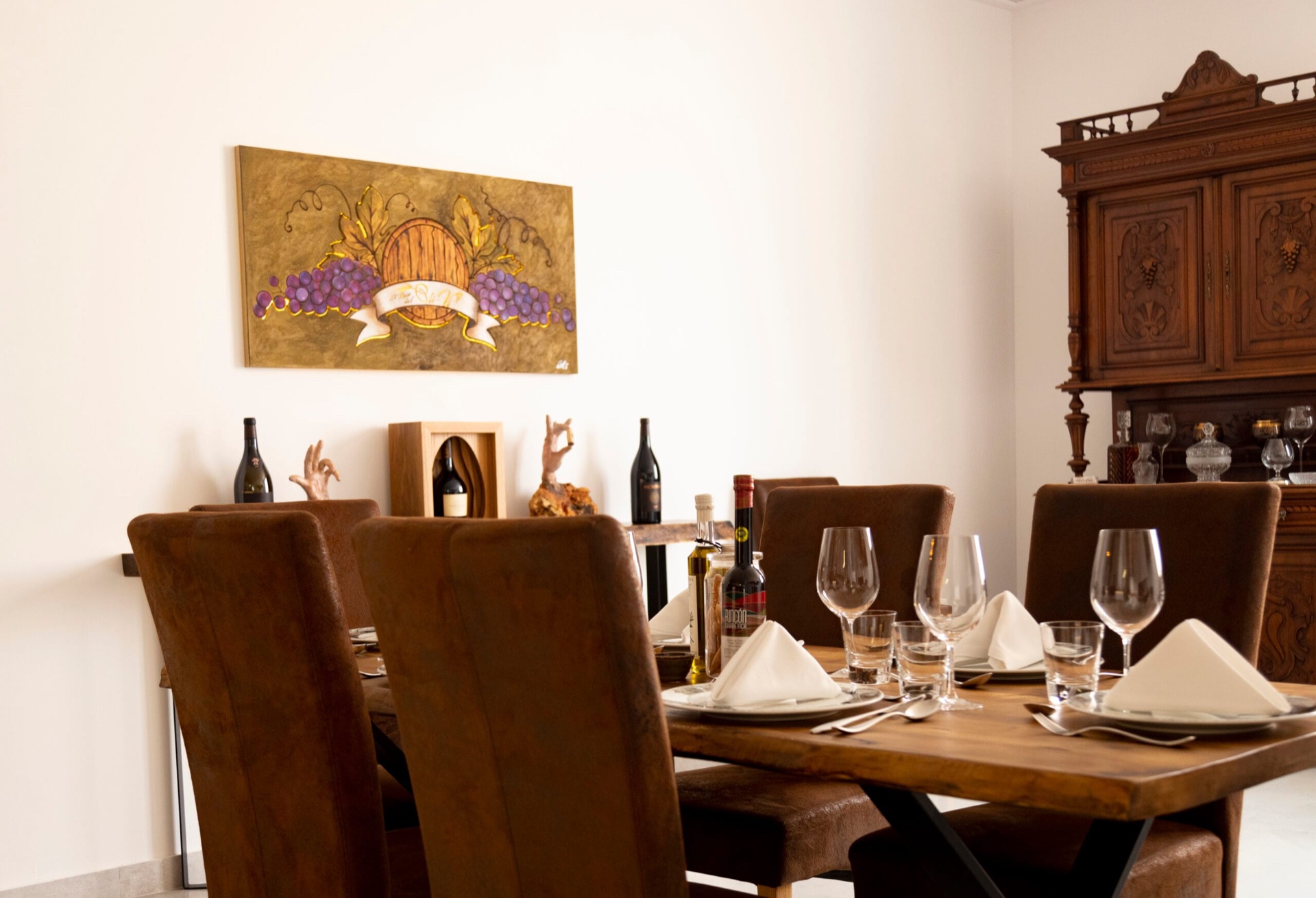 Gedeckter Tisch mit Lederstühlen und Holzanrichte