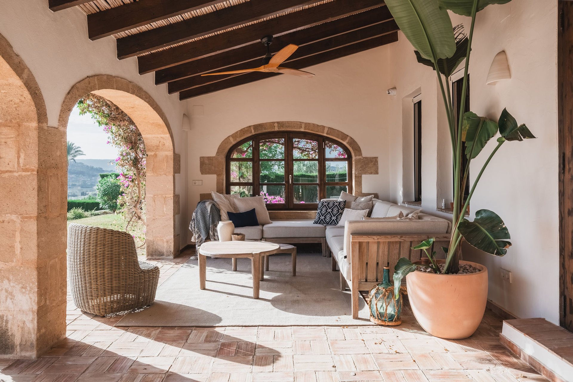 Living room with arches and wooden beams, decorated in natural tones