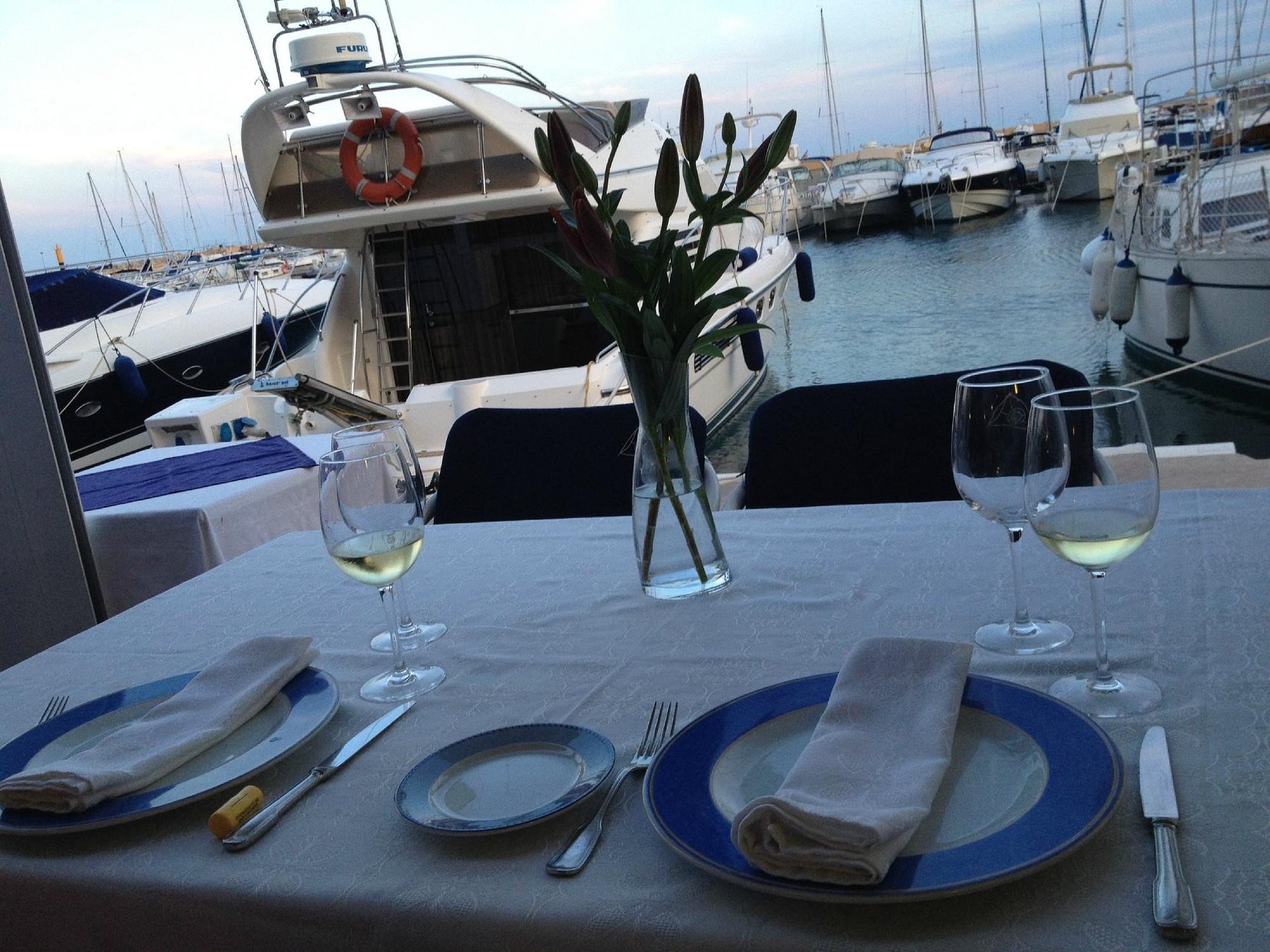 Une table en terrasse face aux bateaux de la Marina Greenwich