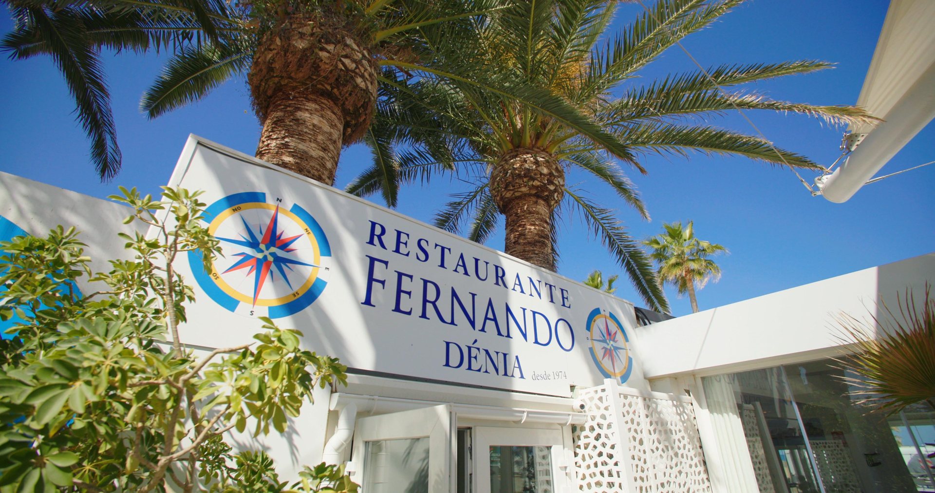 Белый фасад Restaurante Fernando среди пальм на пляже Лес-Маринес