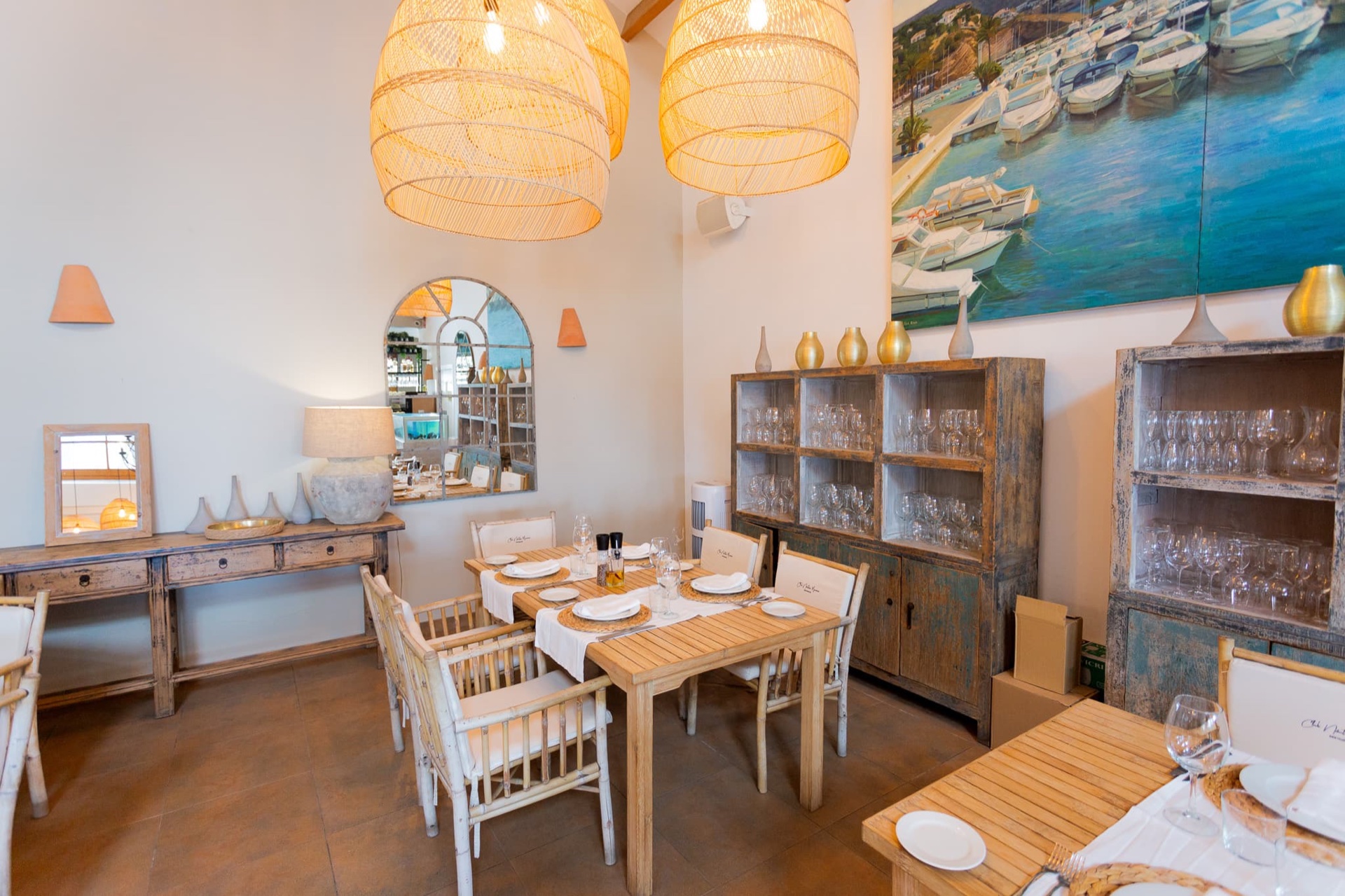 Salle avec lampes en osier et tableau de barques