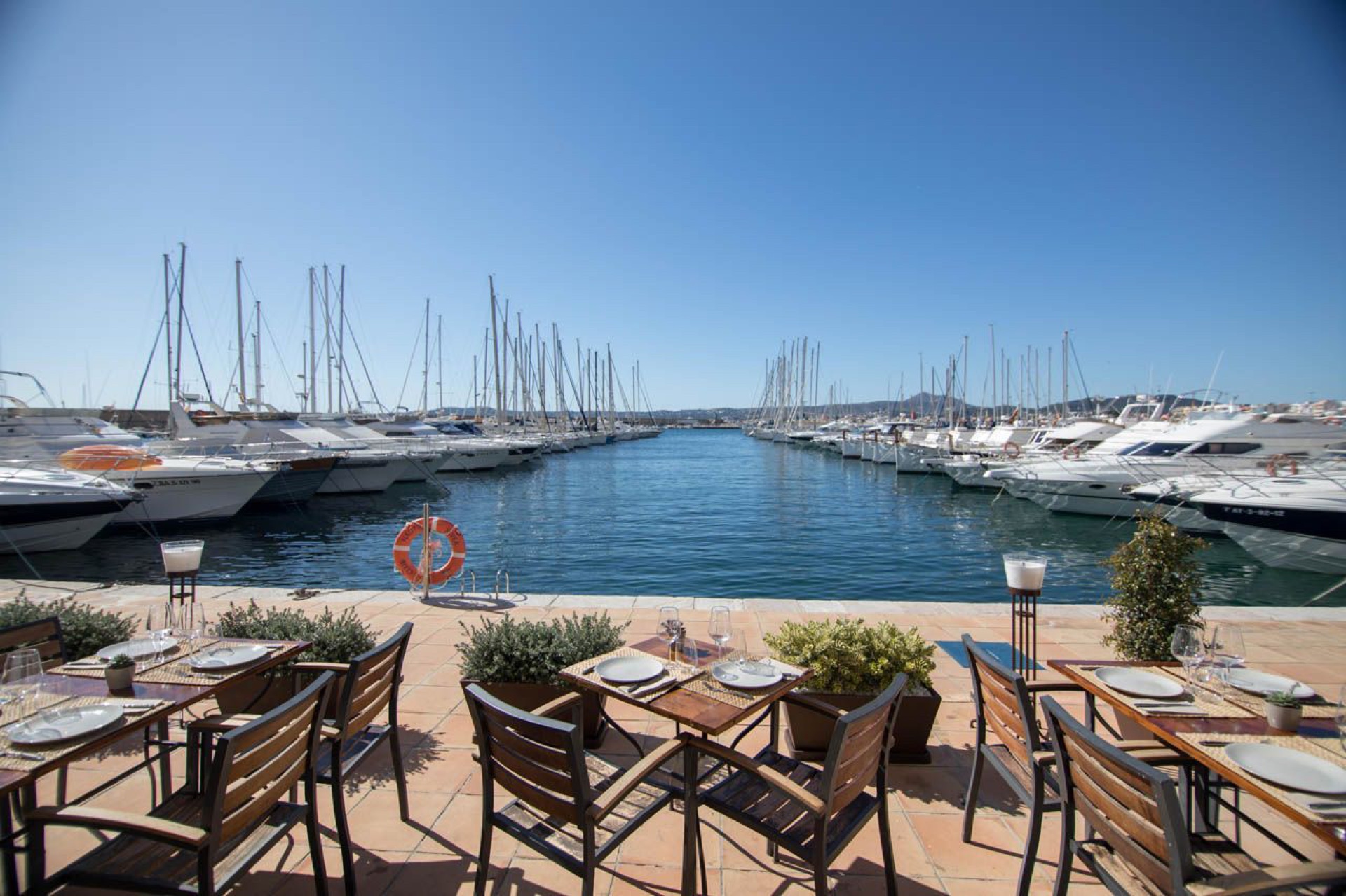 Terrasse mit Tischen an den Liegeplätzen des Hafens von Jávea