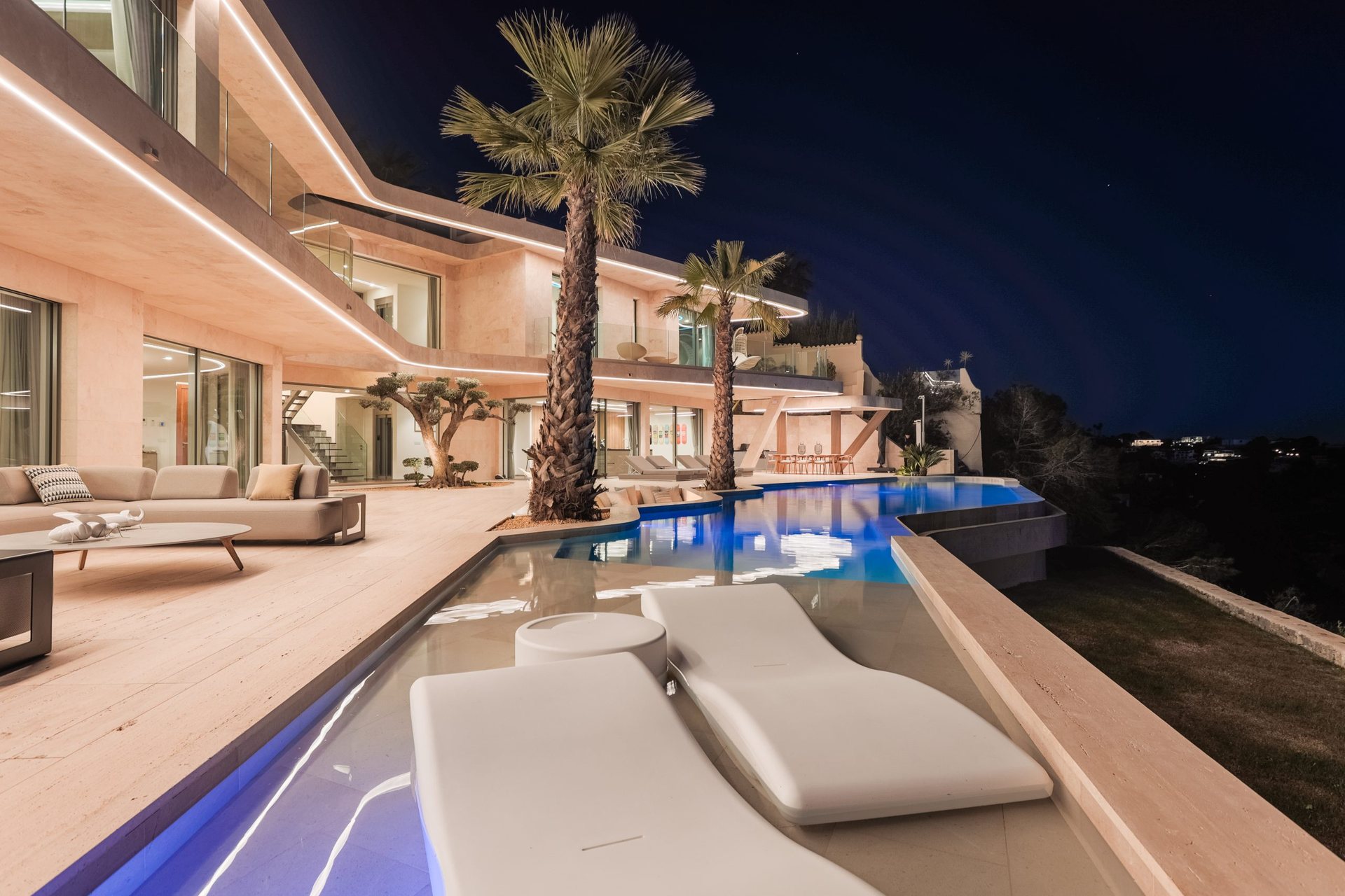 Casa Morgan at dusk: terrace with sun loungers and a lit pool, an interior design project by Tarraula
