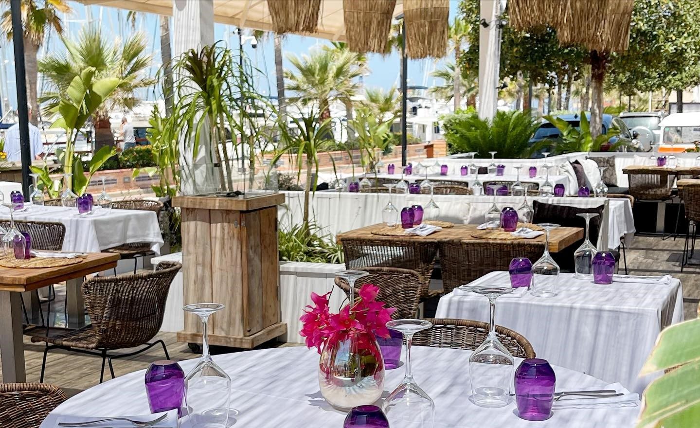 Терраса The Food & Lounge Bar со столами под белыми скатертями и зеленью в Марина-де-Дения