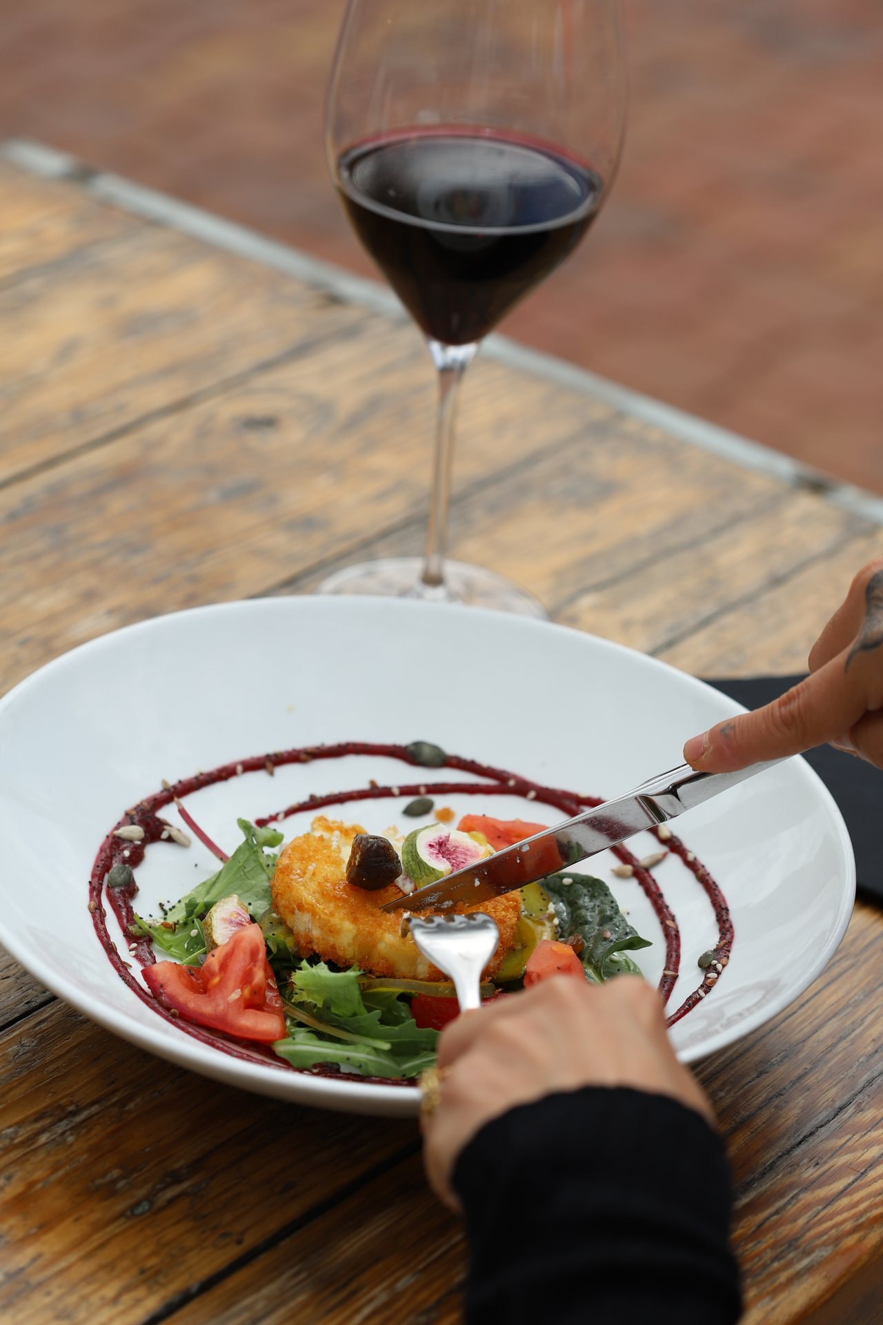 A dish from the menu with a glass of red wine