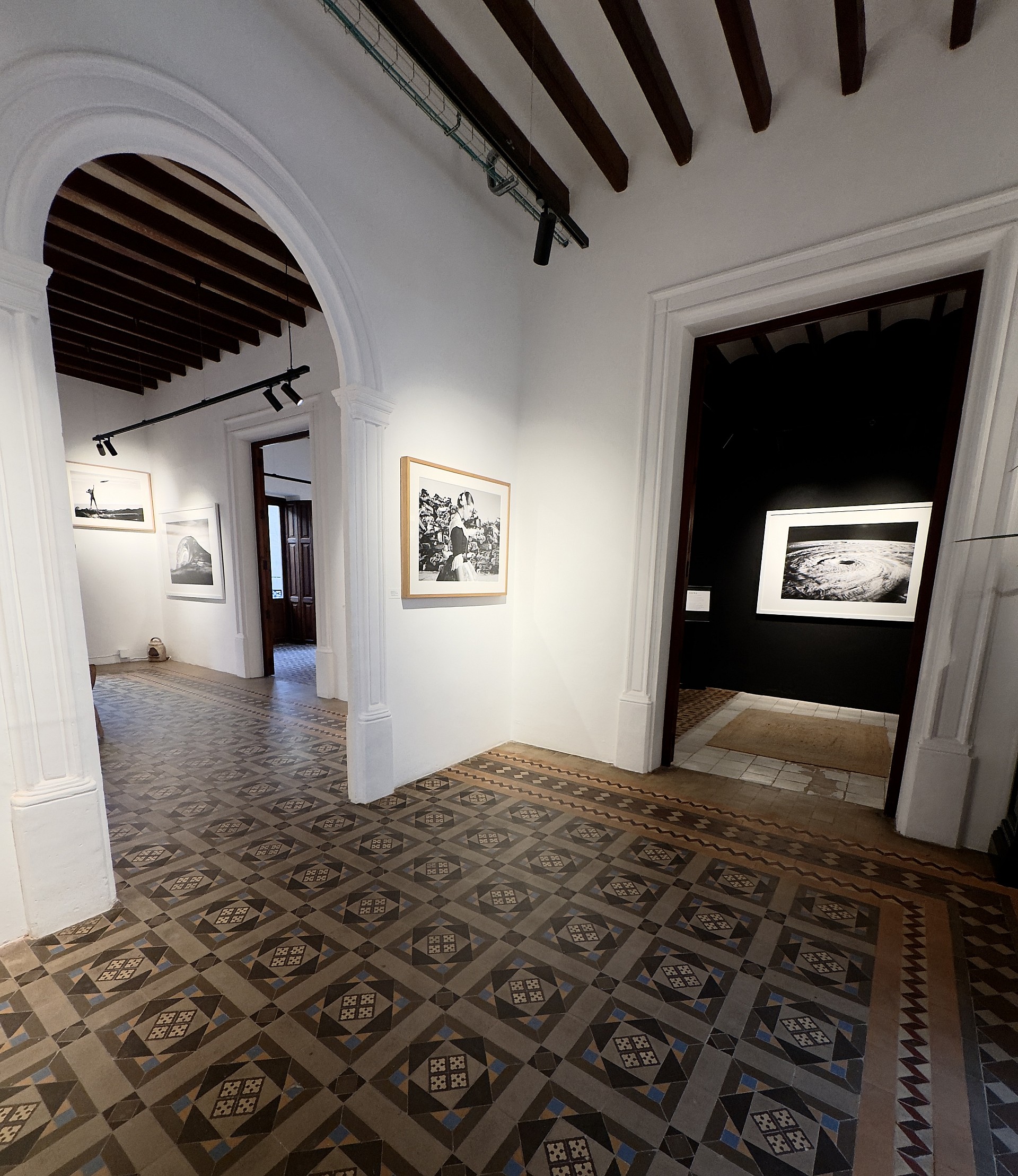 Une salle de la PFZ Gallery, avec carreaux de ciment et photographies aux murs